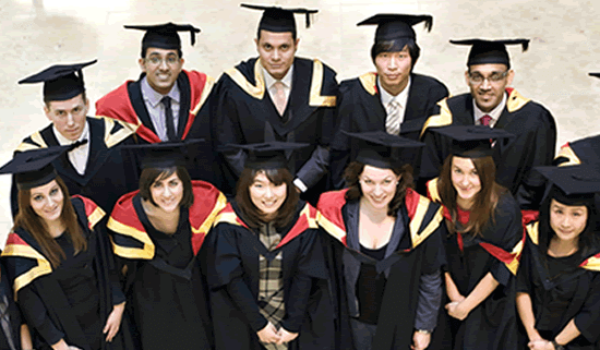 Graduates sitting for photography in gowns.