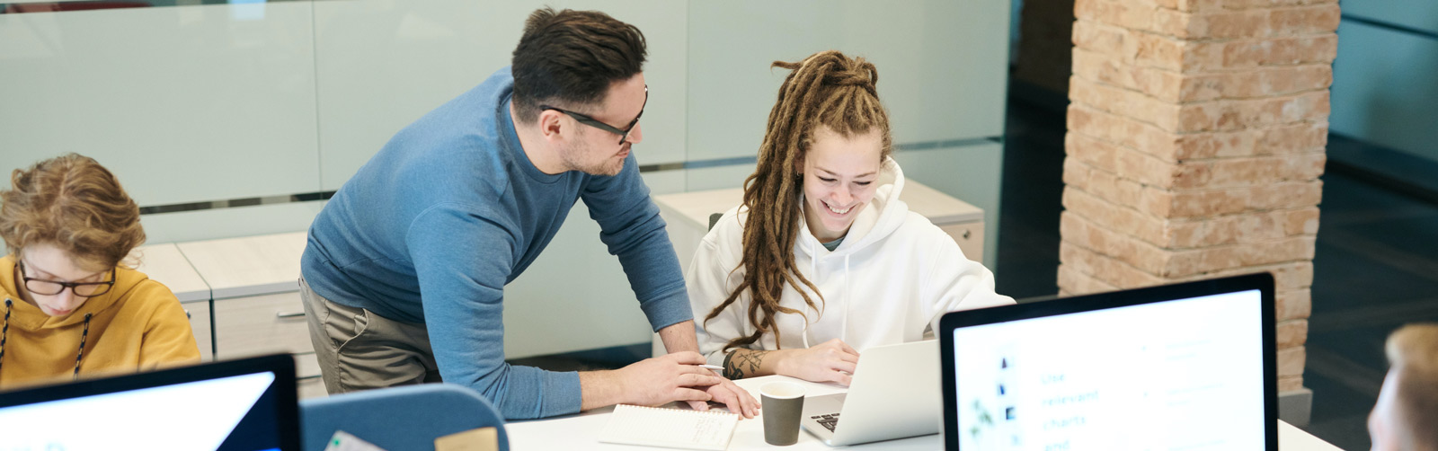 A male and a female chatting looking at a computer screen.