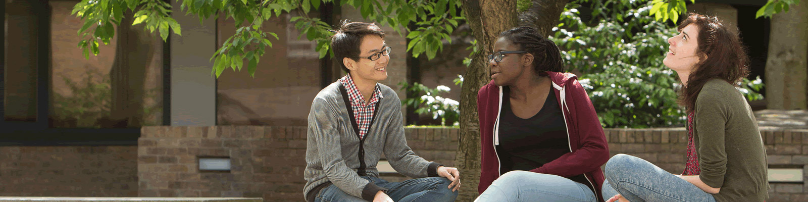 Three students sitting on a bench