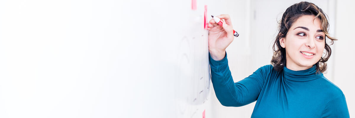 A woman writing on a whiteboard