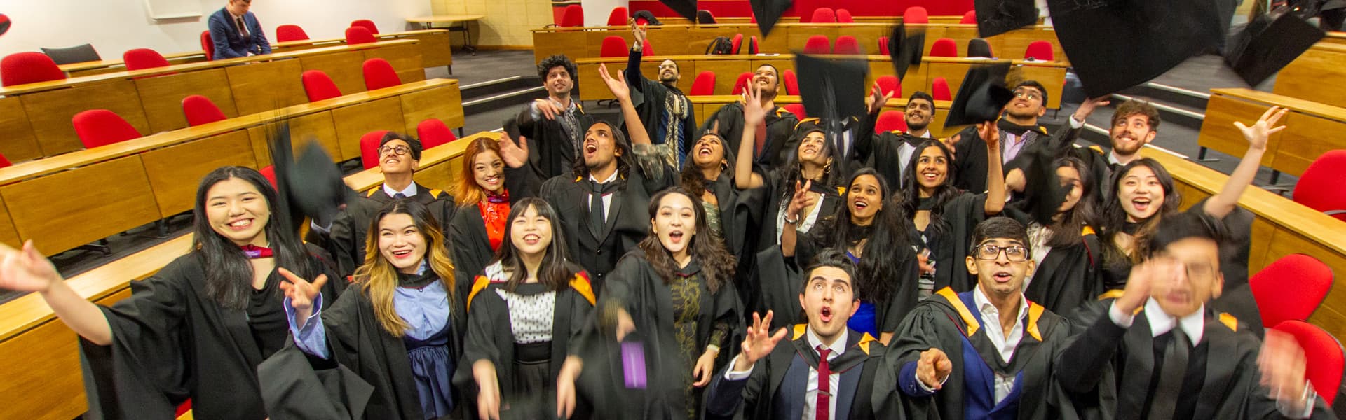 PG graduands throwing their mortar boards