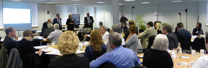 Delegates sat around tables listening to three main speakers.