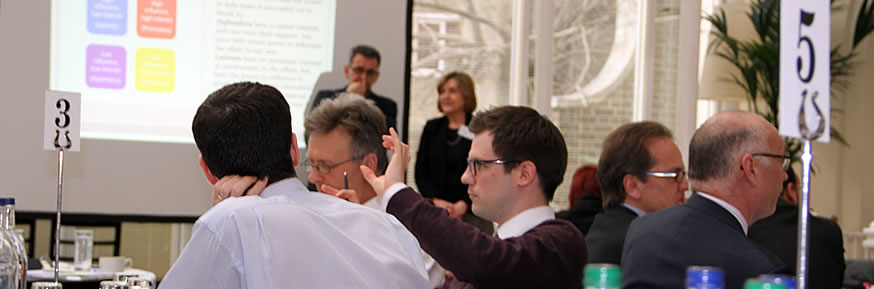 Delegates having a discussion around a table.