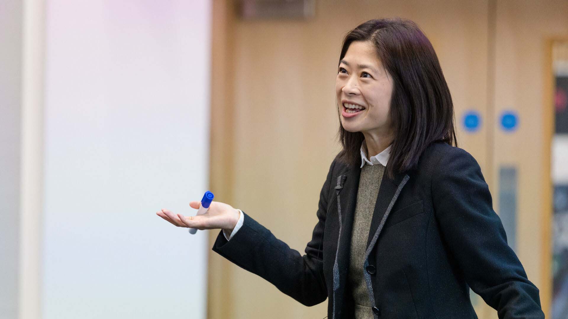Professional woman in blazer speaking while gesturing