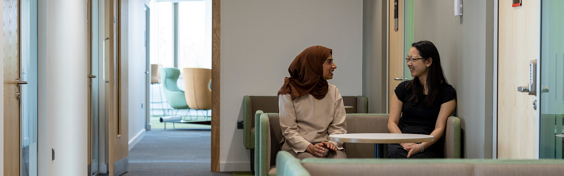 Ruqayyah and Alyssa in conversation in the Management School building