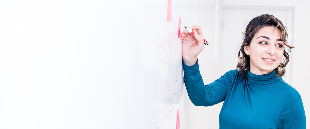 A woman writing on a whiteboard