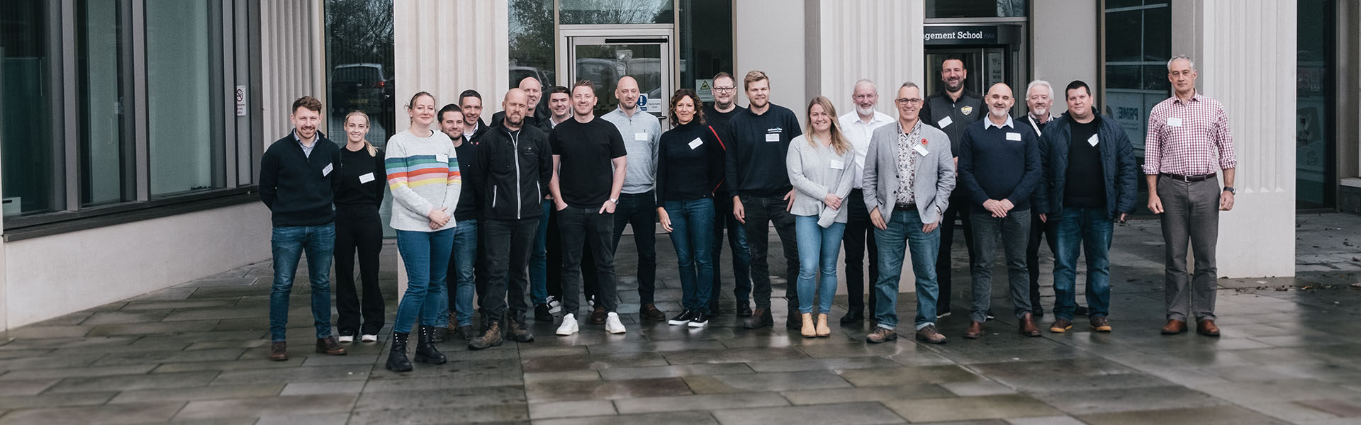 Group of Help to Grow cohort standing by Management School building