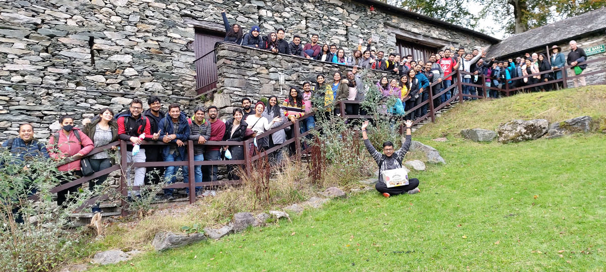 A large group of students lining up in front of a wall.