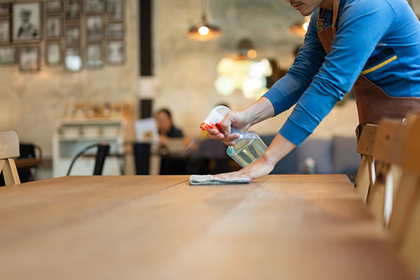 Restaurant worker cleaning a table. 
