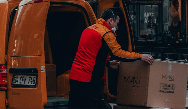 Image of a delivery driver loading packages into their van