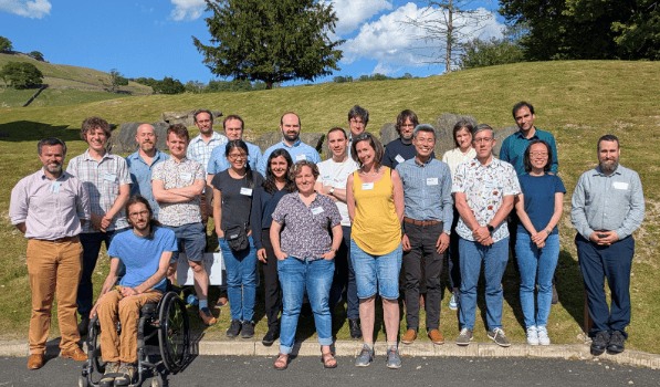 Group of academics standing in front of a hill 