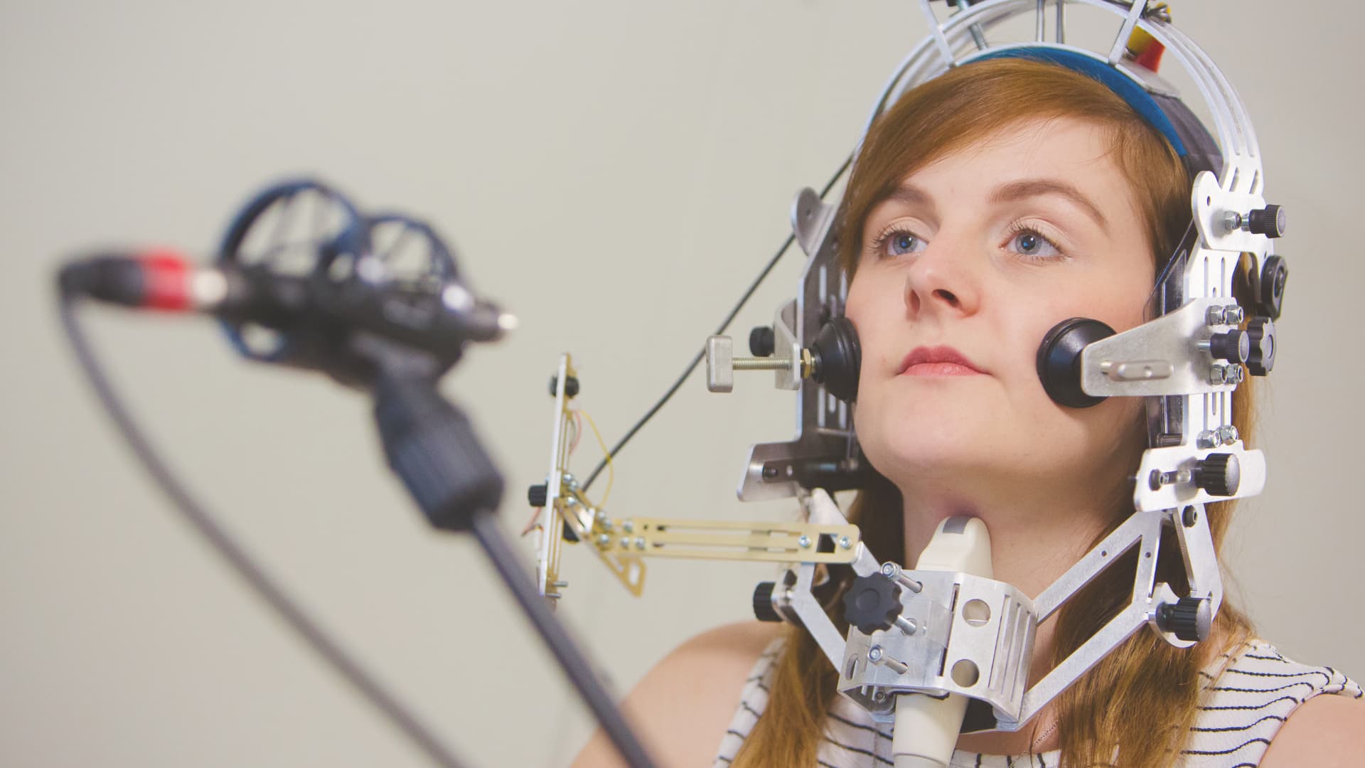 A woman wearing complicated sensors arranged around her head.