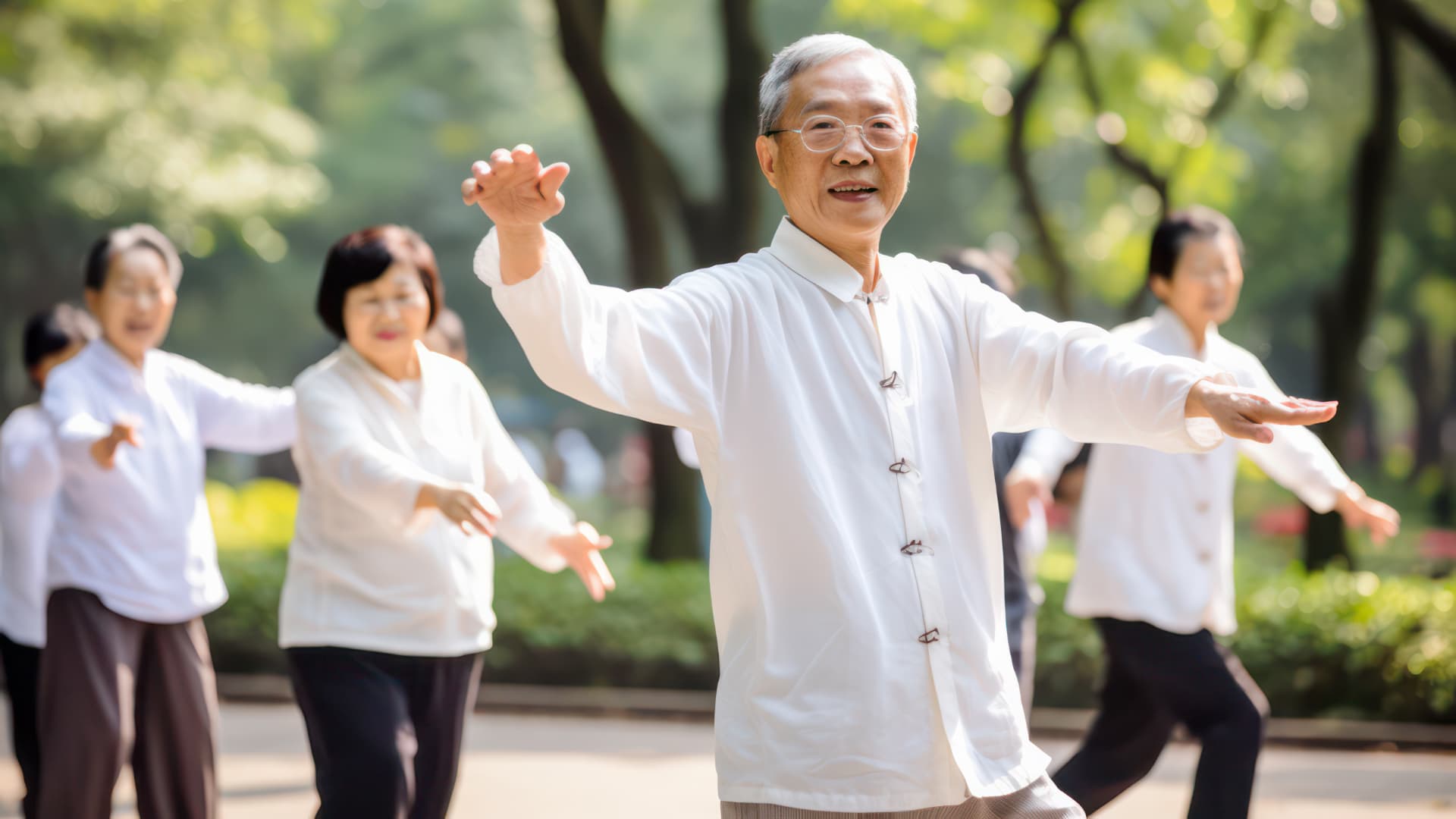 A group of elderly Asian people practice Tai Chi in a sunny park