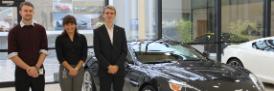 Engineering students standing by Aston Martin car