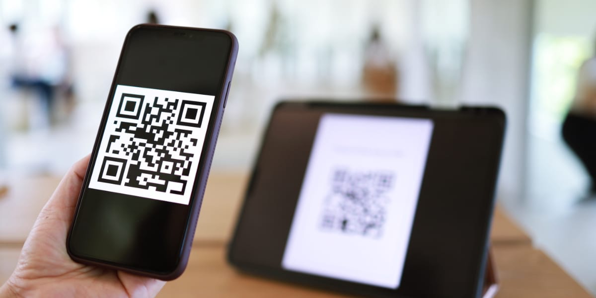 A phone scanning a QR code on a display stand.
