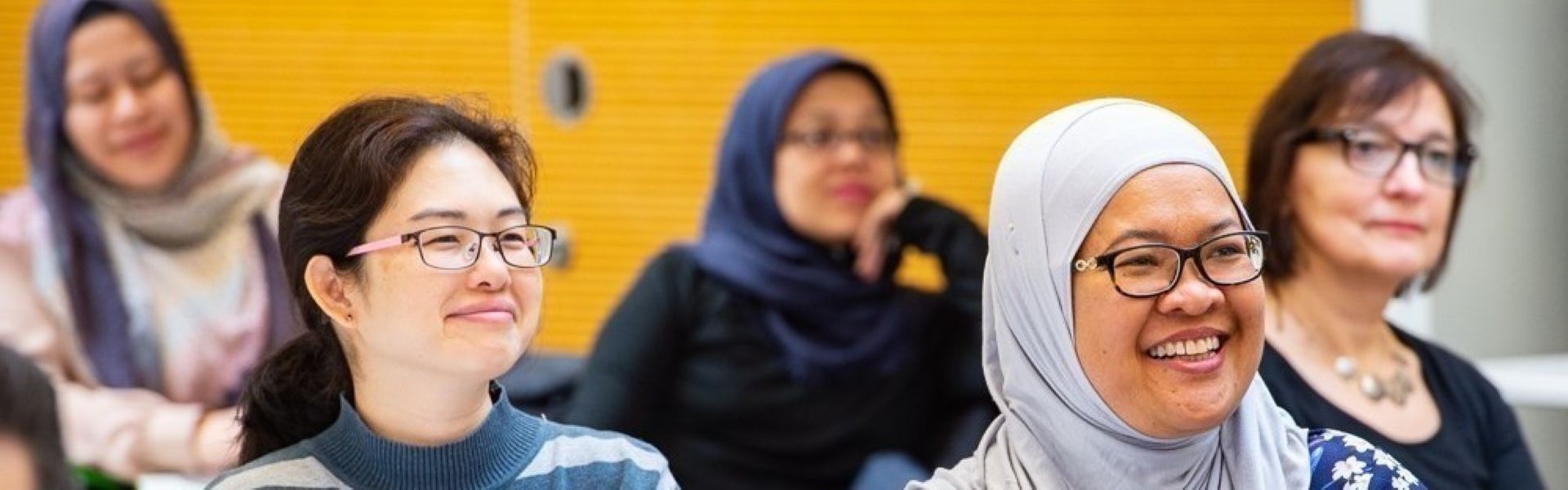 Group of colleagues sitting around a table talking in a workshop