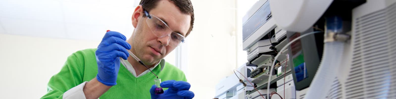 Person placing a drop in a test-tube in laboratory