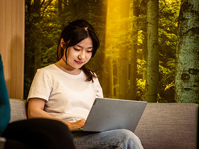 A young woman typing on a laptop writing her UCAS statement.