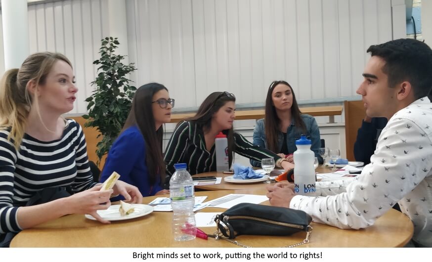 Five students - four female, one male - sitting around a table having a conversation. Marketing Me 2019