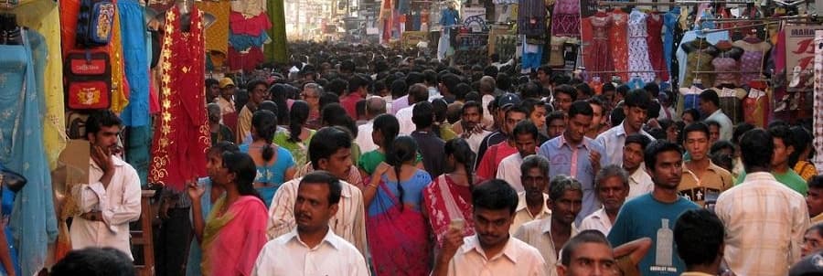 Image of a street in Chennai, India, bustling with people, and stall selling clothes, textiles, etc.