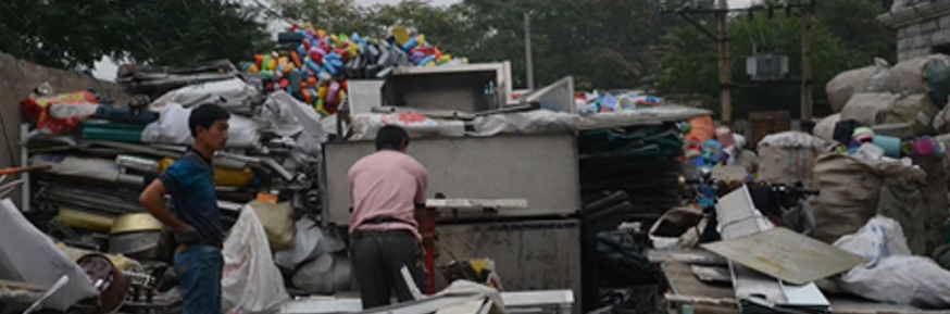 Two men sorting waste at informal plastic waste centre