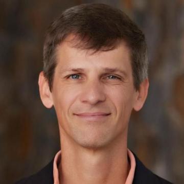 Photo of Dr John Virdin, head and shoulders visible, he is smiling.