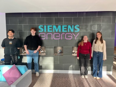 Four students stood in front of Siemens logo