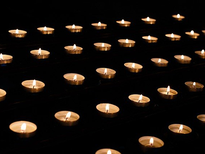 Parallel rows of lit tealight candles