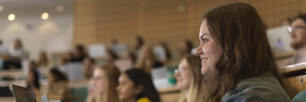 A student with a laptop in a lecture theatre