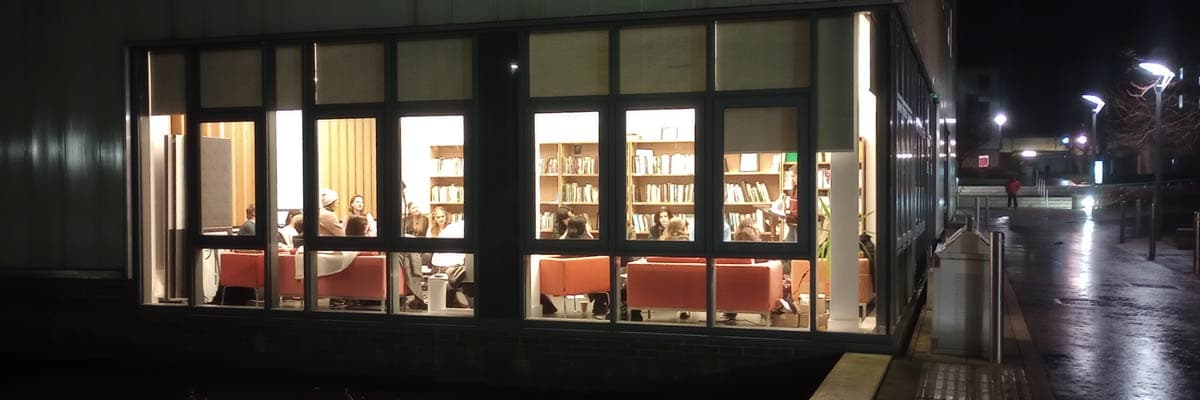 Looking into the LICA building from the outside at night with the lights on