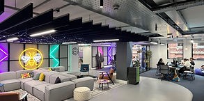 An open plan space with comfy grey couches and decorative lighting