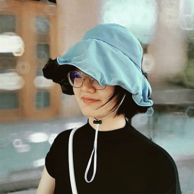 Ann walking down street wearing blue hat