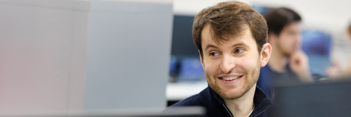 Student smiling to the left of the camera