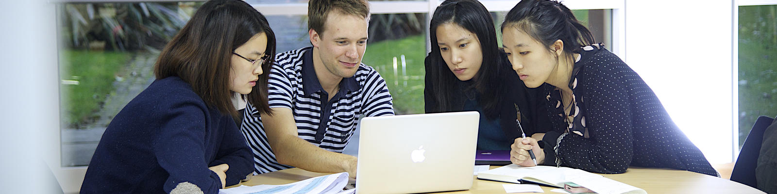 Students collaborating around a laptop