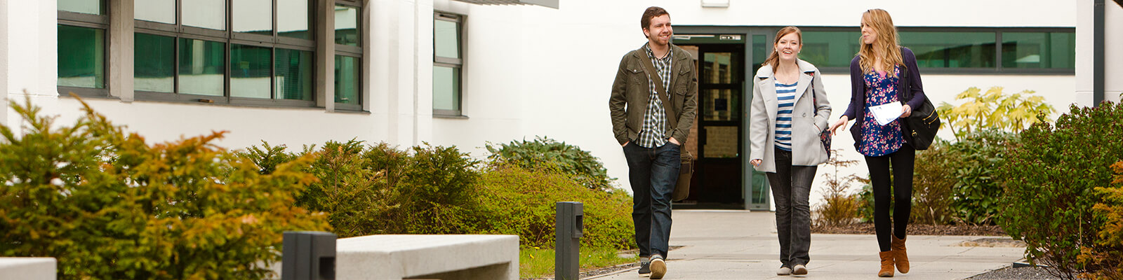 Three students walking on footpath