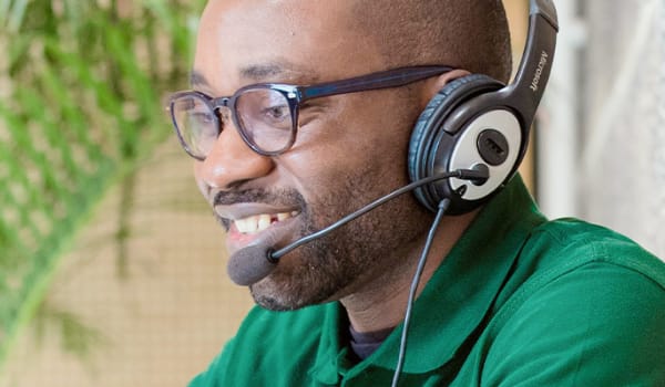 Man wearing a headset and microphone completing distance learning work