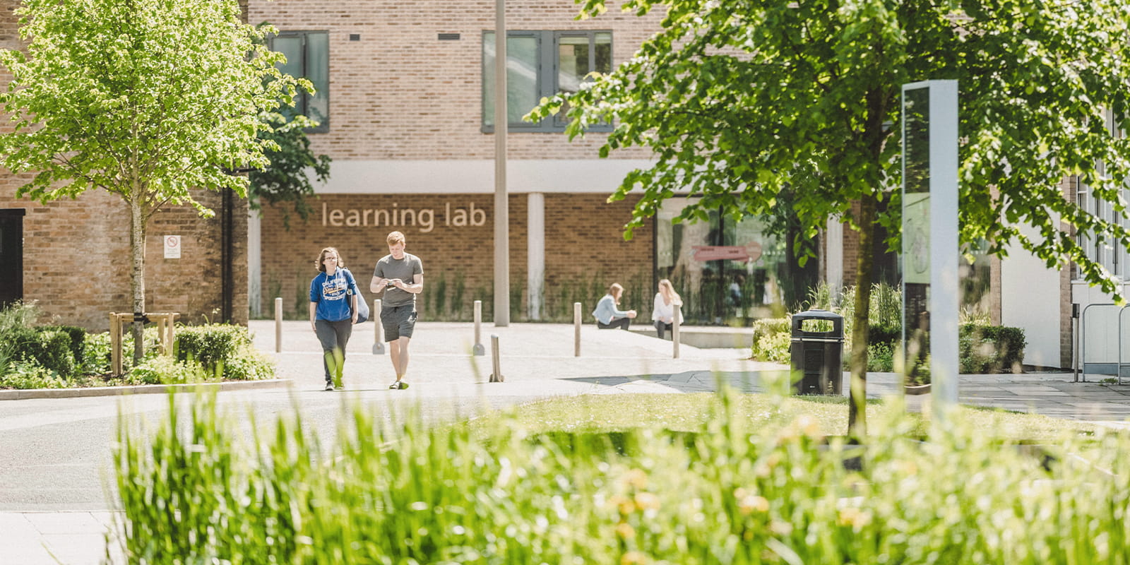 four students waking across Lancaster Square on campus