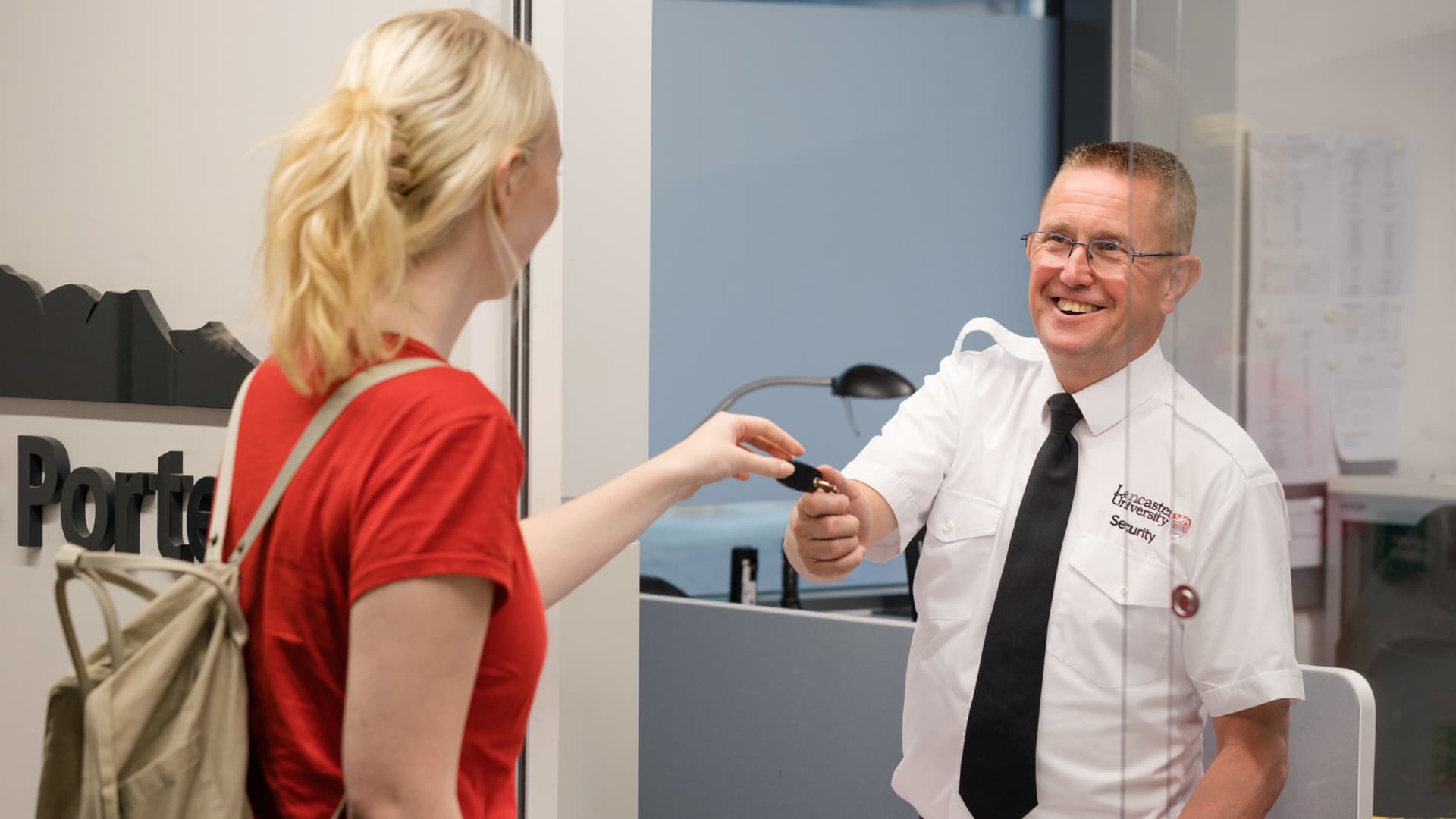 A porter hands keys to a student.