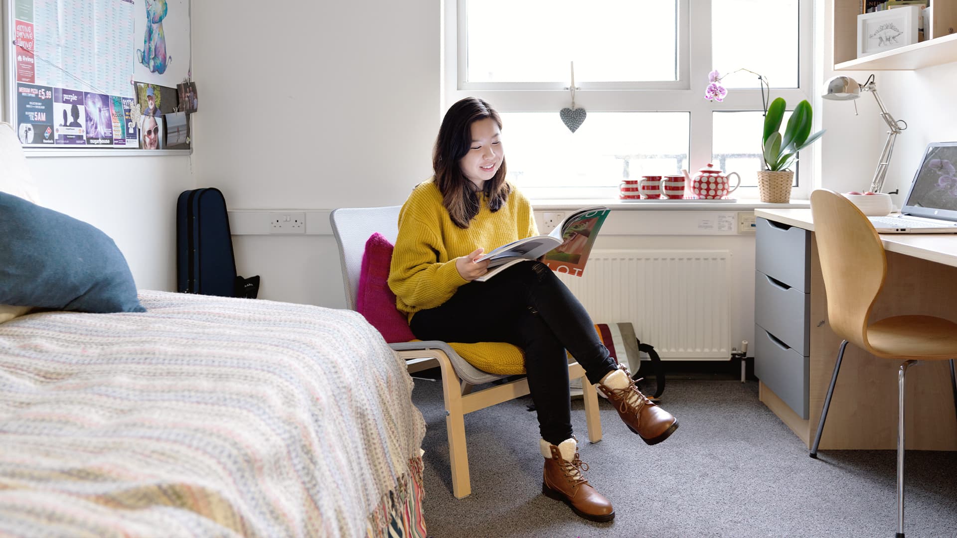 A student reads a book in their accommodation