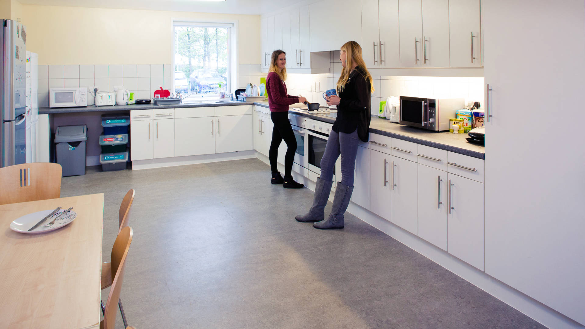 Two students talk in a kitchen in a student flat