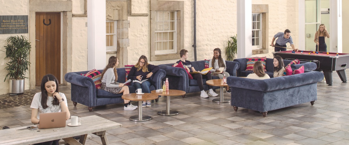 Students sit in groups in the Barker House Farm atrium.