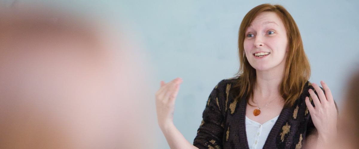 A lecturer talks enthusiastically in front of a classroom