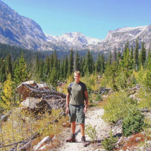 A study abroad student stands amongst the Canadian mountains and wilderness.