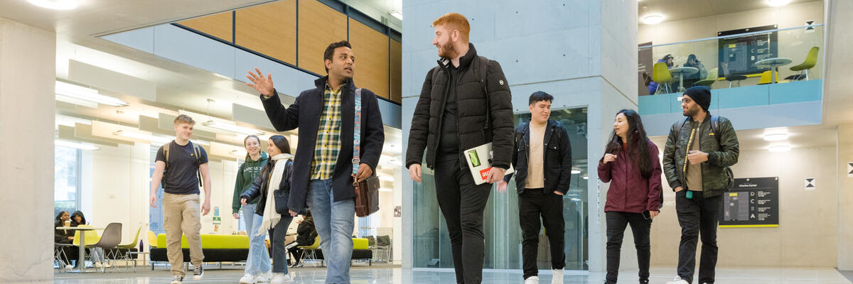 Students walk across the Charles Carter Building foyer.