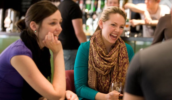 Three students laugh in a group in County Bar