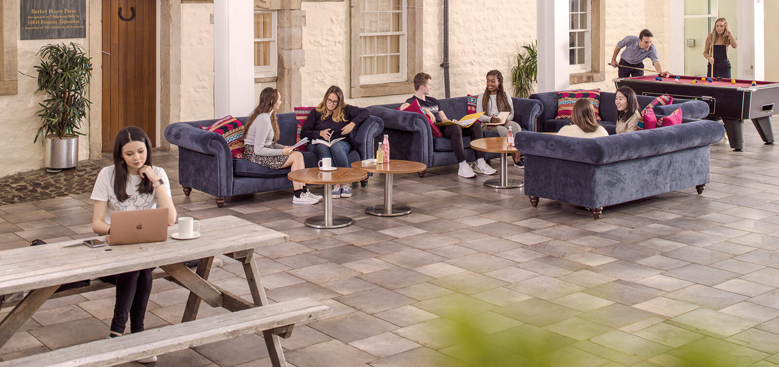 A group of students sitting around benches inside Barker House Farm