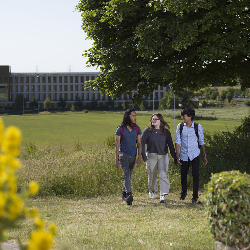 Three students walking on campus