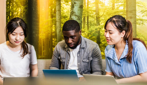 Students sitting around a laptop screen