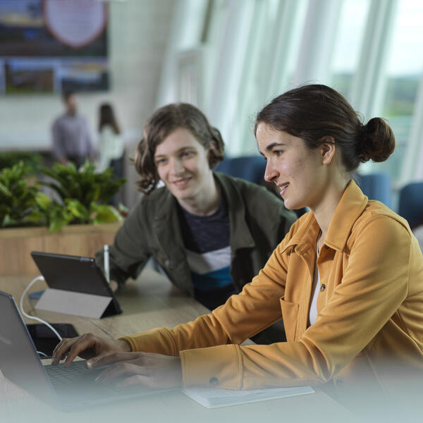 Students sat in front of a laptop