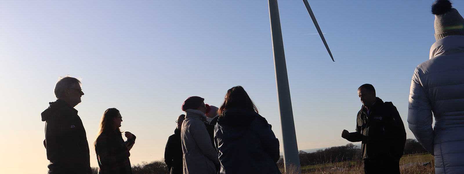 Lancaster University's wind turbine with people attending a talk on sustainability.